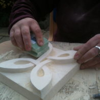 A student finishes their stone carving